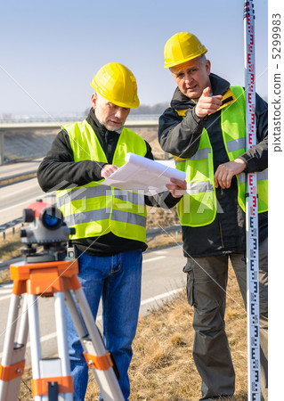 Geodesist read plans on construction site Geodesist read plans on construction site 5299983