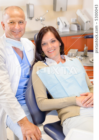 Dentist and female patient at surgery office Dentist and female patient at surgery office 5300043