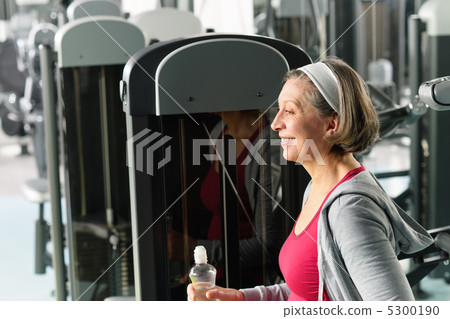 Senior woman relax sitting by fitness machine 5300190
