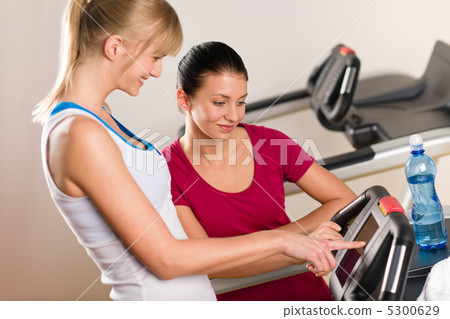 Young female friends chatting in fitness center Young female friends chatting in fitness center 5300629