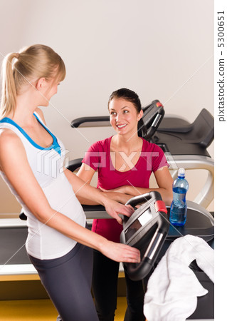 Young female friends chatting in fitness center 5300651