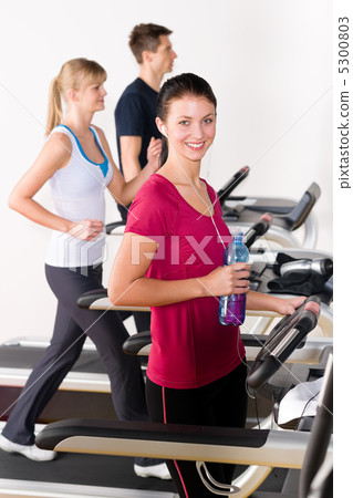 Young woman on fitness running belt Young woman on fitness running belt 5300803