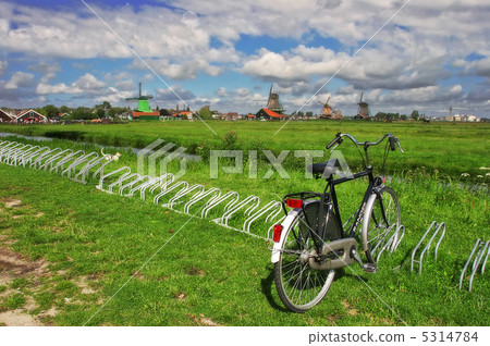 Bicycle on the green lawn against the backdrop of windmills. Bicycle on the green lawn against the backdrop of windmills. 5314784