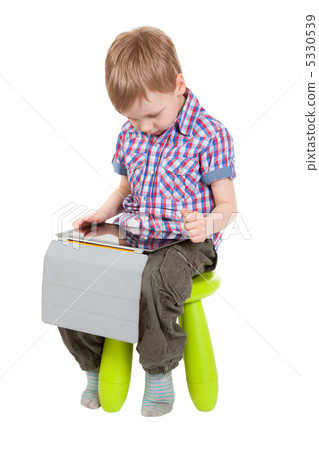 boy with a Tablet PC sitting on a chair boy with a Tablet PC sitting on a chair 5330539