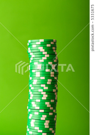 Stack of red casino chips against green background 5331675