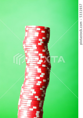 Stack of red casino chips against green background 5331937