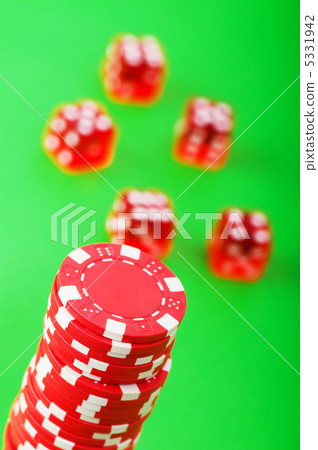 Casino chips and dice against green background 5331942