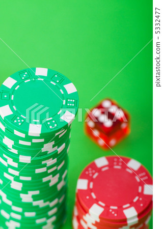 Casino chips and dice against green background 5332477