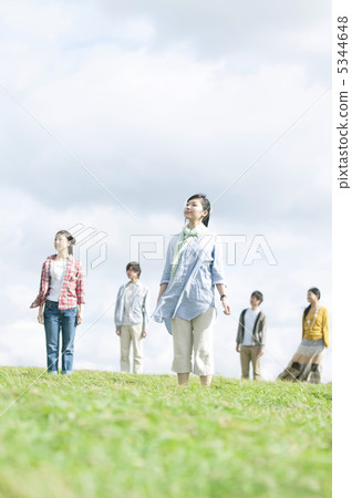 Young people standing in the grassland Young people standing in the grassland 5344648