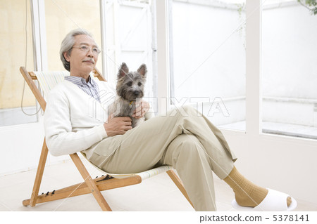 老人坐拿著狗的椅子 老人坐拿著狗的椅子 5378141