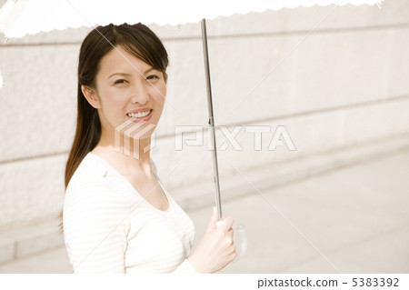 A woman walking in the street with a parasol 5383392