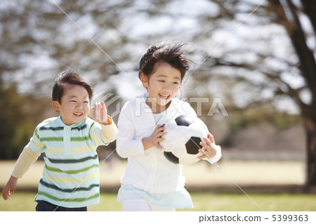 A girl running with a soccer ball 5399363
