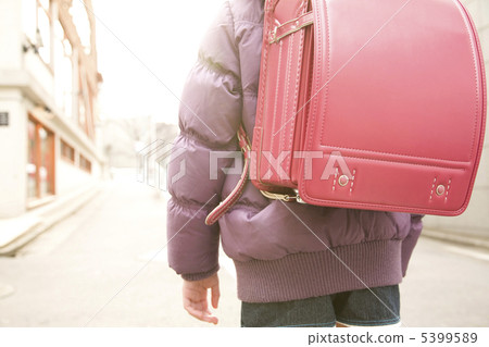 Elementary school student carrying a school bag Elementary school student carrying a school bag 5399589