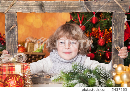 Happy child looking into wooden frame 5437363