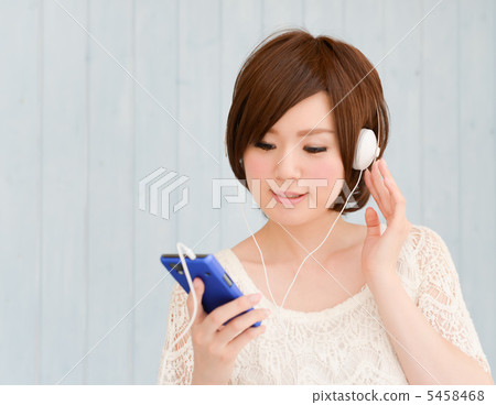 A woman listening to music on a smartphone A woman listening to music on a smartphone 5458468