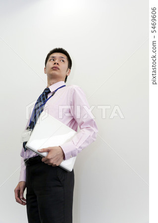 A businessman standing with a laptop computer A businessman standing with a laptop computer 5469606