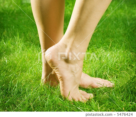 Woman's bare feet in green grass 5476424