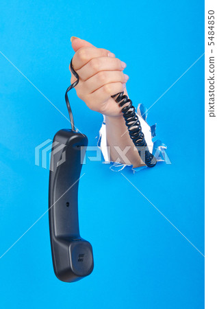 Hand with phone out of paper hole Hand with phone out of paper hole 5484850
