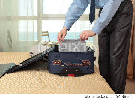 Businessman packing a suitcase 5496653