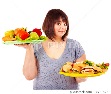 Woman choosing between fruit and hamburger. Woman choosing between fruit and hamburger. 5511328