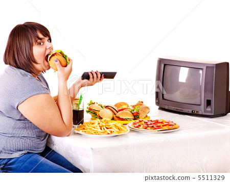 Woman eating fast food and watching TV. Woman eating fast food and watching TV. 5511329