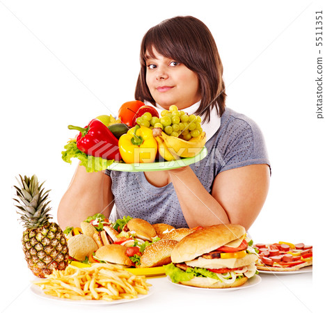 Woman choosing between fruit and hamburger. 5511351