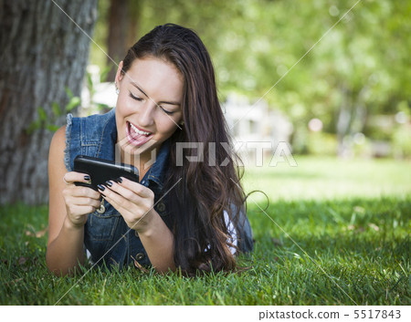 Mixed Race Young Female Texting on Cell Phone Outside Mixed Race Young Female Texting on Cell Phone Outside 5517843