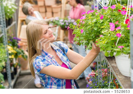 Woman at garden centre shopping for flowers 5528653