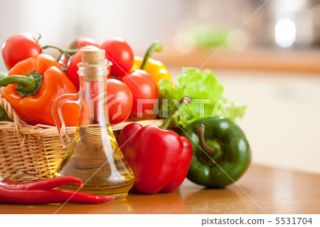 Sunflower oil in bottle and fresh vegetables in basket on the ta 5531704