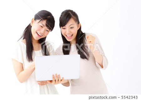 使用便攜式計算機的兩個女孩 使用便攜式計算機的兩個女孩 5542343