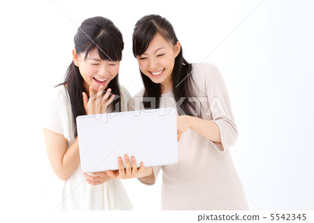 Two girls using a laptop computer Two girls using a laptop computer 5542345