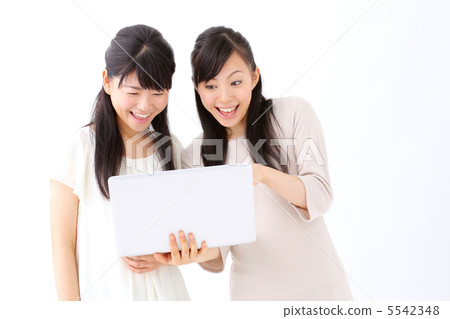 使用便攜式計算機的兩個女孩 使用便攜式計算機的兩個女孩 5542348