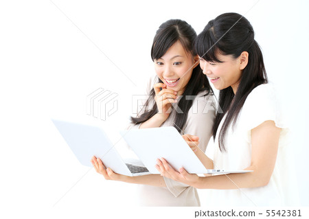 Two girls using a laptop computer Two girls using a laptop computer 5542381