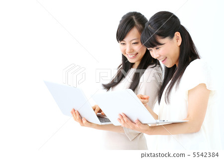 使用便攜式計算機的兩個女孩 使用便攜式計算機的兩個女孩 5542384