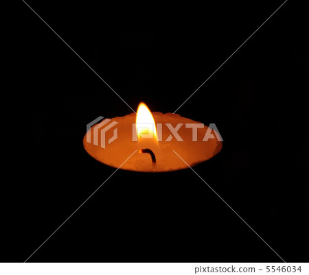 A single burning yellow candle A single burning yellow candle 5546034