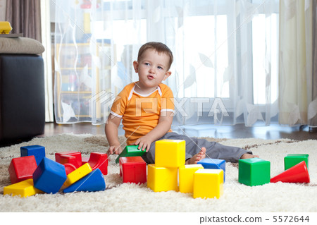 Child playing with building blocks at home. Child playing with building blocks at home. 5572644