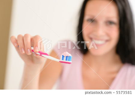Toothpaste on toothbrush close-up teeth brushing 5573581