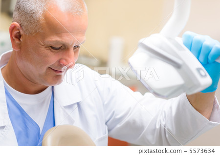 Dentist male at dental office Dentist male at dental office 5573634