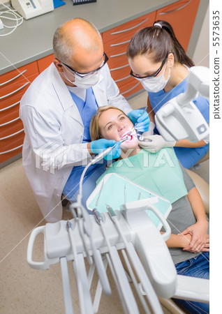 Dentist with nurse check patient teeth Dentist with nurse check patient teeth 5573635