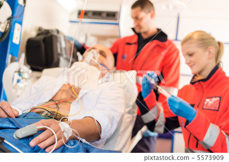 Sick patient with paramedic in ambulance treatment 5573909