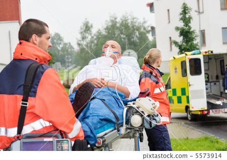 Paramedics with patient on stretcher ambulance aid 5573914