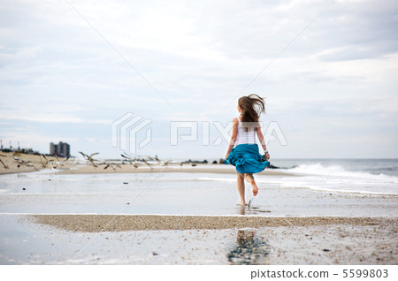 Beautiful young woman has fun on the ocean shore 5599803