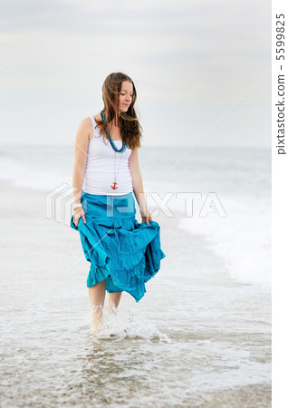 Beautiful young woman has fun on the ocean shore 5599825