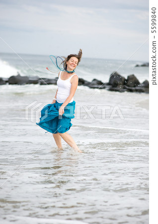 Beautiful young woman has fun on the ocean shore 5599840