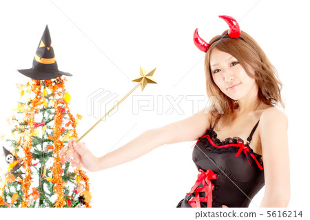 採取在萬聖夜樹前面的一個逗人喜愛的女性惡魔一個性感的姿勢 採取在萬聖夜樹前面的一個逗人喜愛的女性惡魔一個性感的姿勢 5616214