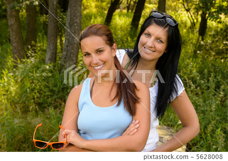 Teen girl smiling with mother in background Teen girl smiling with mother in background 5628008