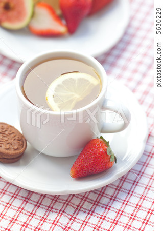 cup of tea,cookie, fig and strawberries on a plate cup of tea,cookie, fig and strawberries on a plate 5630229