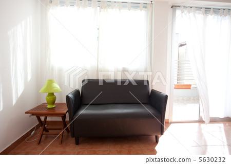 black sofa and a lamp on the bedside table on a background of cu black sofa and a lamp on the bedside table on a background of cu 5630232