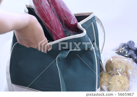 A woman who puts shopping in an eco bag 5665967
