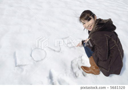 一位年輕的女士在雪地上寫愛 5681320